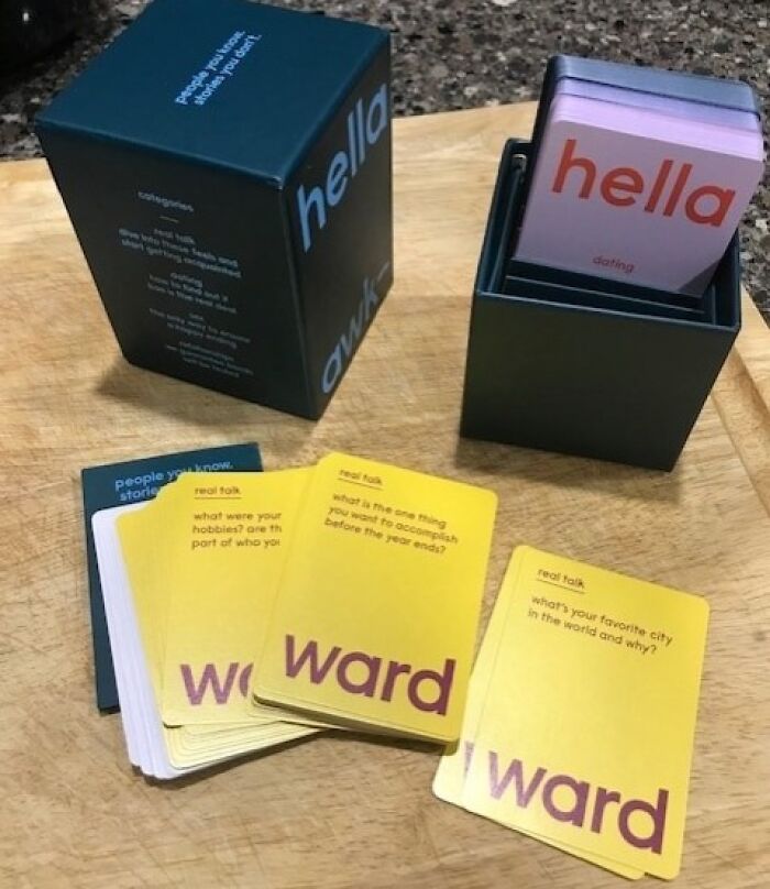 Hella conversation cards from a Shark Tank pitch, laid out on a wooden surface with colorful questions for real talk and dating.