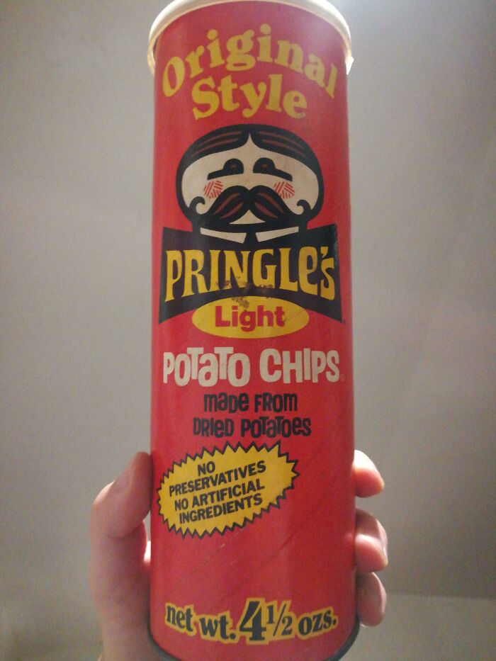 Vintage Pringles can held in hand, showcasing original style potato chips packaging as things used to look.