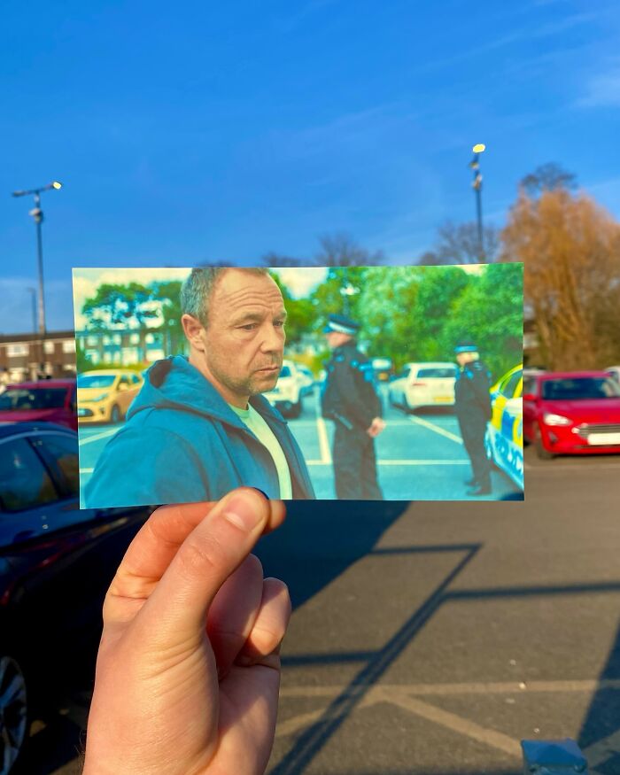 Hand holding photo of a movie scene with police officers, showing real-life filming locations of TV show scenes.