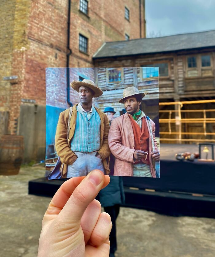 Hand holding photo of two actors in period costumes, showing real-life filming locations of movie and TV show scenes.