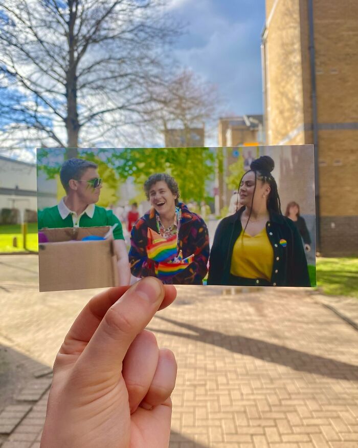 Hand holding a photo comparing real-life filming locations of movie and TV show scenes outdoors on a sunny day.