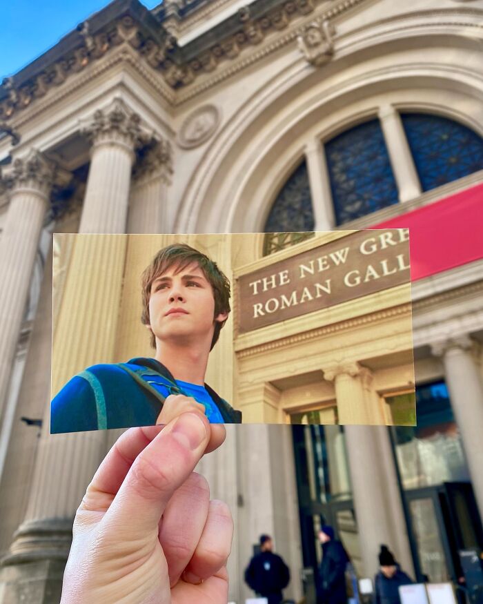 Hand holding a movie scene photo matching the real-life filming location in front of a grand classical building with columns.