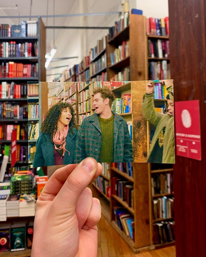 Hand holding a photo of movie scene inside the same bookstore, showcasing real-life filming locations comparison.