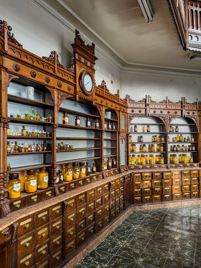 Vintage apothecary shelves with labeled jars and ornate woodwork showcasing how things used to look in old pharmacies.