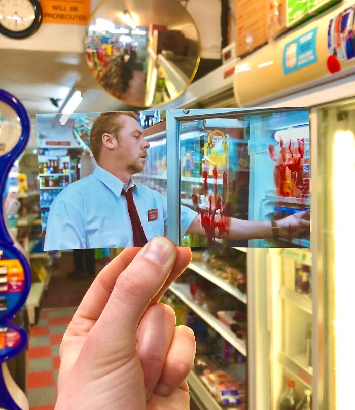 Hand holding a movie scene photo with bloodied hand inside a real-life filming location convenience store.