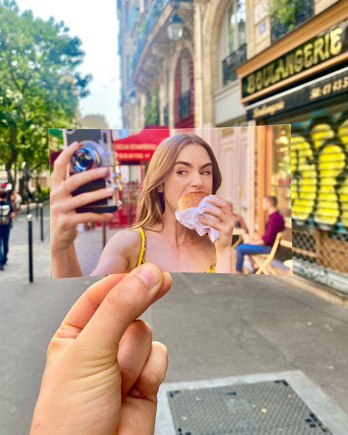 Hand holding a photo of a woman eating a croissant in front of the real-life filming location on a city street.