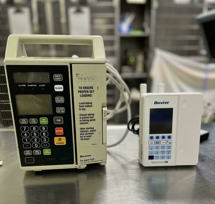 Two Baxter volumetric infusion pumps on a metal surface, showing how medical equipment used to look.