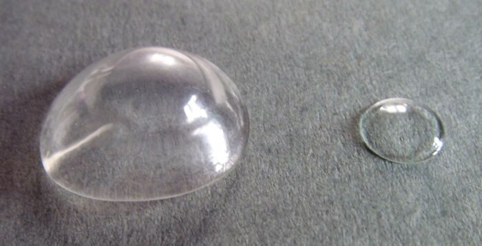 Clear vintage contact lenses on a gray surface showcasing how things used to look in eyewear history.