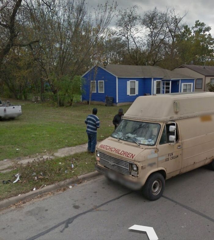 Beige ice cream van with faded watch children sign parked by a blue house with two men nearby, odd thing on Google Earth.