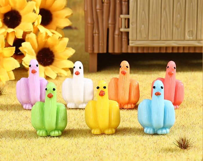 Colorful quirky bird figurines arranged on grass with sunflowers in the background, showcasing funny finds under 10 dollars.