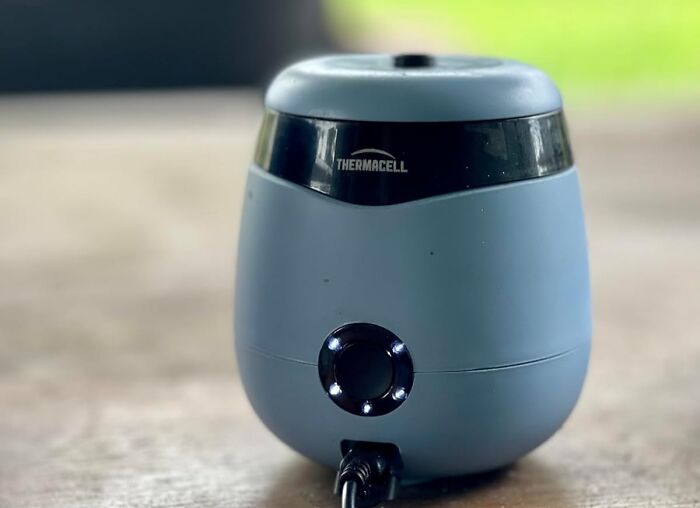 Blue Thermacell device on wooden surface highlighting Amazon Memorial Day bargain product close-up.