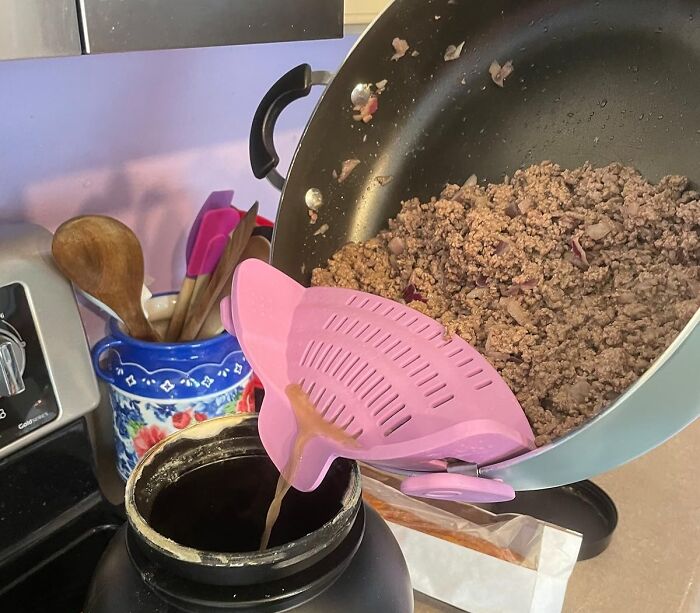 Pink strainer attached to a pan draining grease into a container, demonstrating useful everyday finds fixing kitchen annoyances.