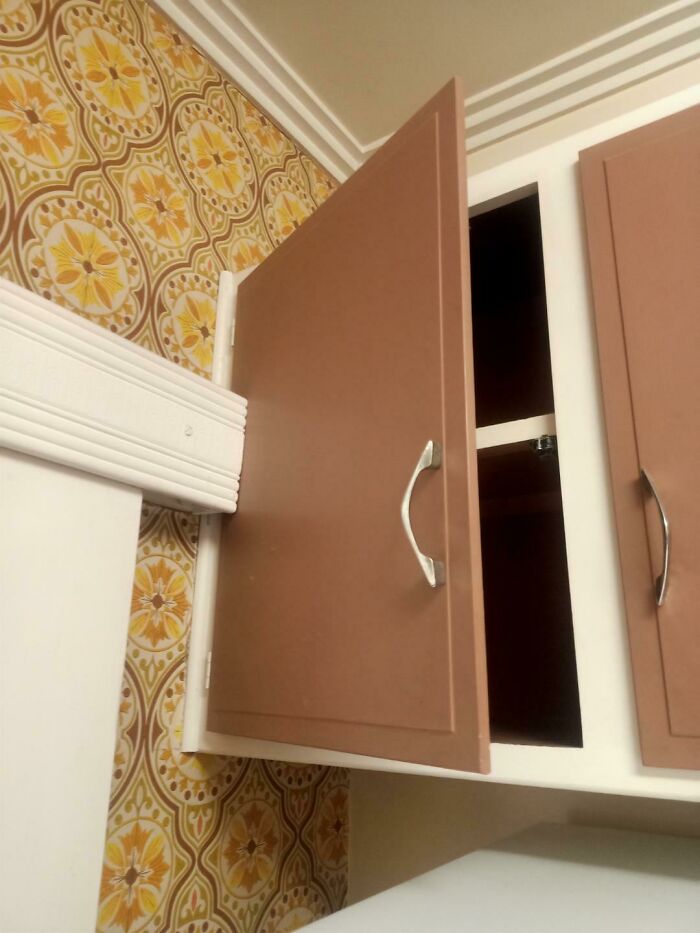 Kitchen cabinet door blocked by wall trim, illustrating dumb interior design decisions lacking common sense and functionality.