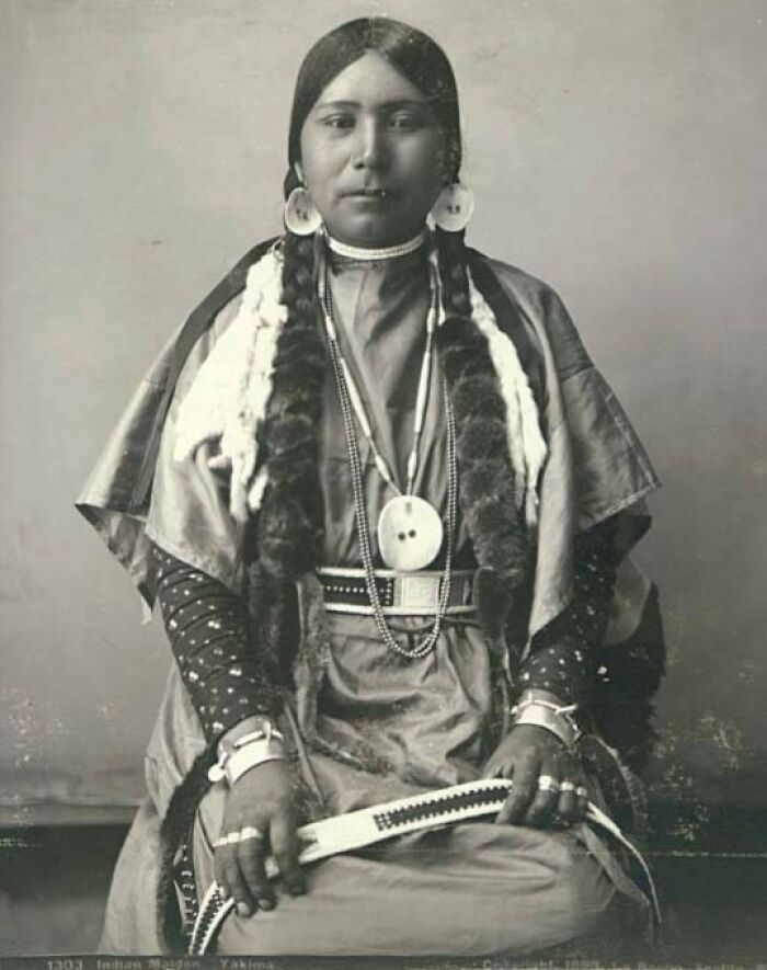 Native American female strength captured in a time-weathered photograph showing traditional attire and jewelry.