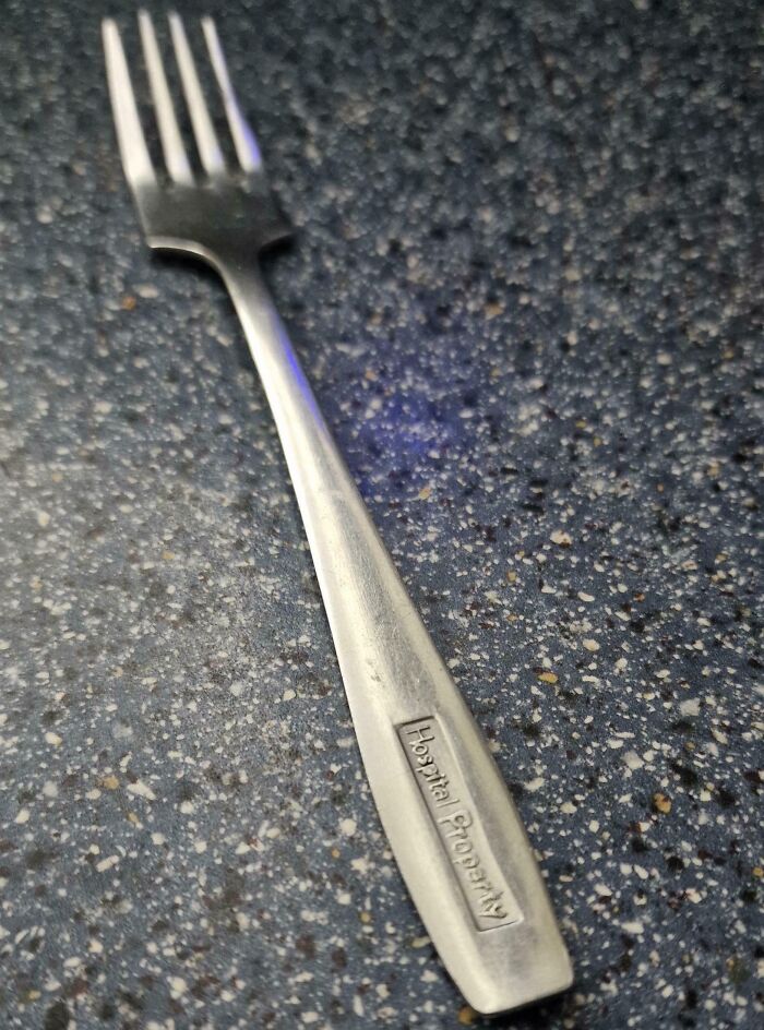 Close-up of a vintage fork labeled Hospital Property found among bizarre items in old houses, puzzling many collectors.