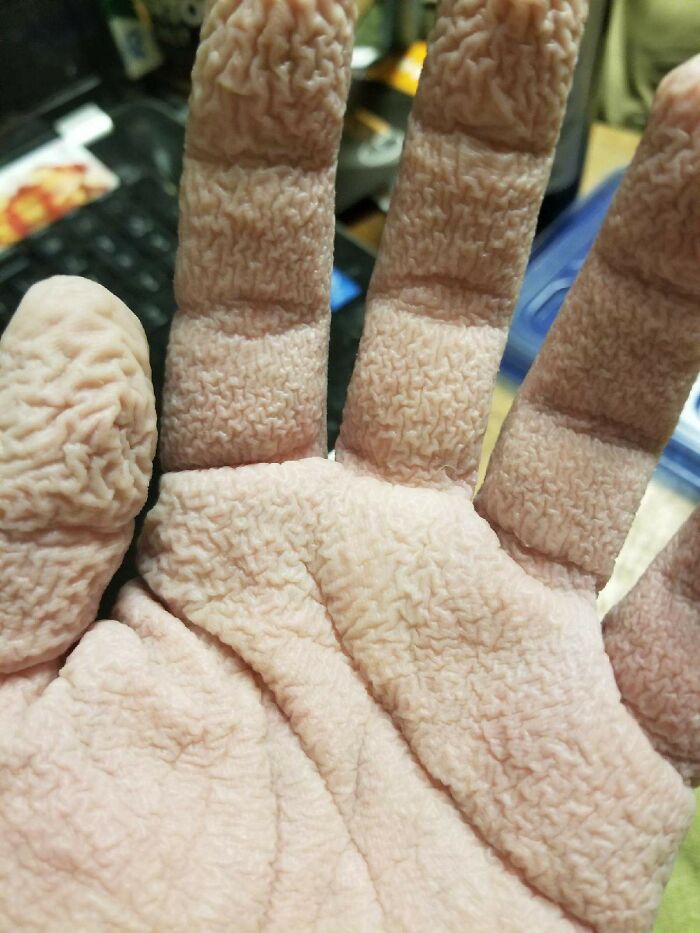 Close-up of a human hand with extremely wrinkled skin showing bizarre and fascinating texture details of the human body.