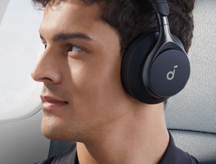Young man wearing black wireless headphones, enjoying music with Amazon Memorial Day sale discounts on tech accessories.