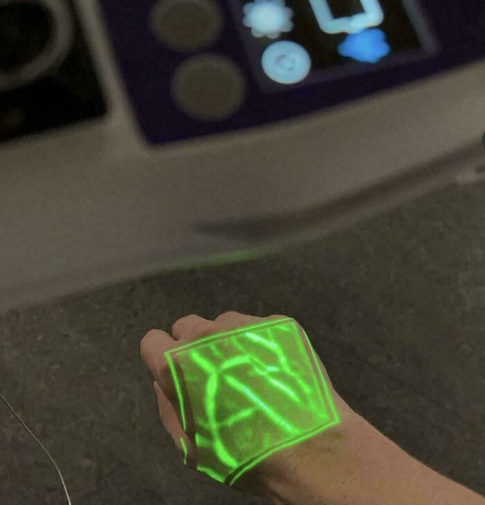 Hand with green vein visualization projection shown on skin, demonstrating fascinating pictures for curious minds learning about the world.