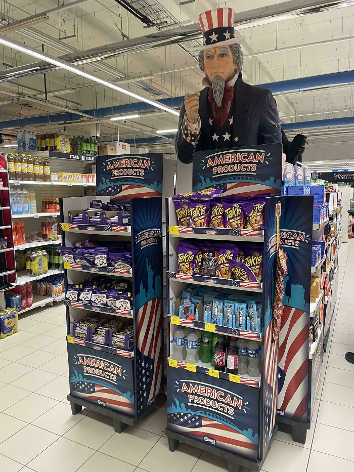 Store display with American products including snacks and drinks under a large Uncle Sam figure, for curious minds to explore.