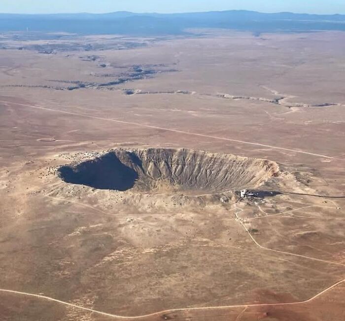 A large crater in a barren desert landscape, one of the odd things found on Google Earth shared by users.
