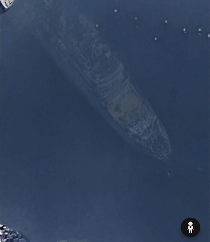 Sunken shipwreck visible near boats in a harbor found as an odd thing on Google Earth shared by users.