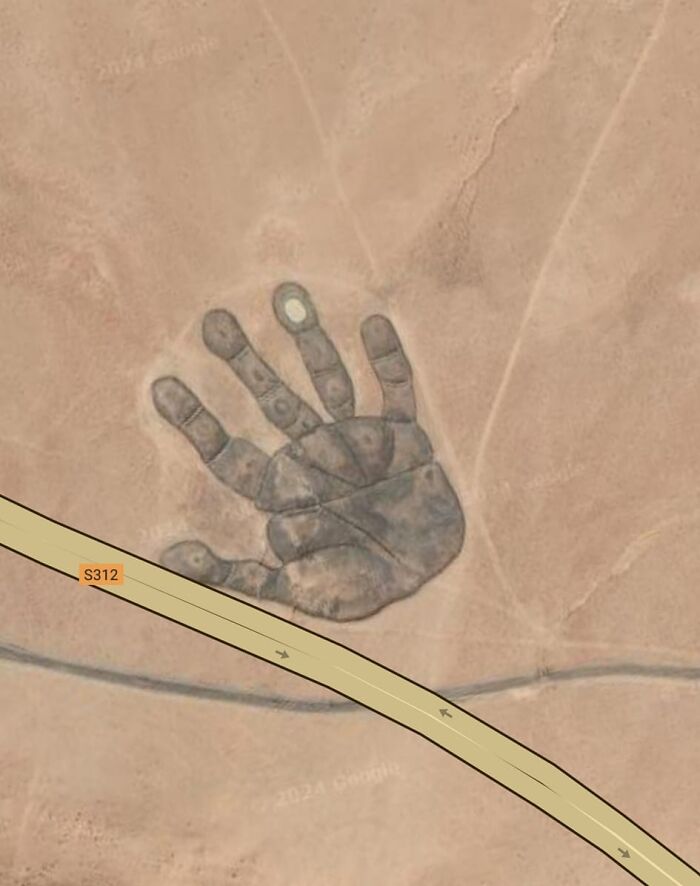 Odd hand-shaped formation visible on desert land found on Google Earth, showcasing unusual and intriguing sights.