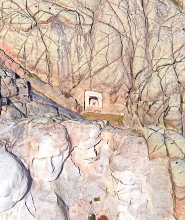 Aerial view of Mount Rushmore carving seen on Google Earth showing four US presidents' faces in rock.