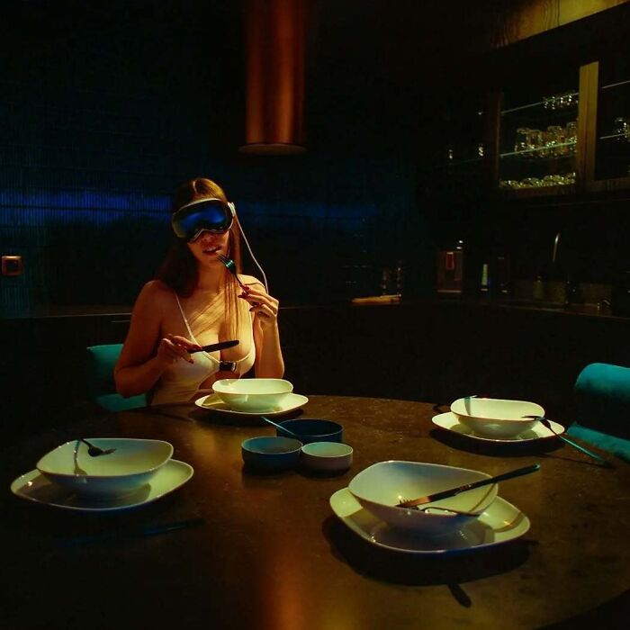 Photographer using vintage cameras captures intimate, cinematic-looking shots of a woman dining alone in dim light.