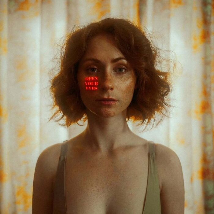 Red-haired woman with freckles posing in soft light, captured using vintage cameras for intimate cinematic-looking shots.