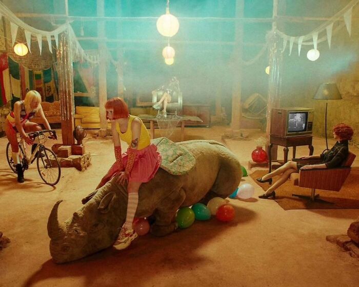 Vintage camera photographer captures intimate, cinematic-style scene with colorful characters and surreal indoor setting.