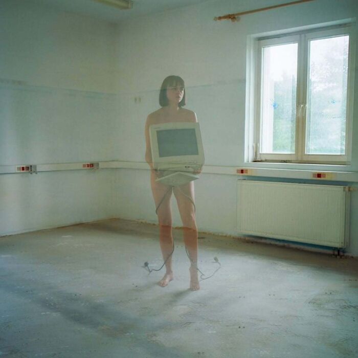 A photographer uses vintage cameras to capture intimate, cinematic-looking shots in a minimalistic room.