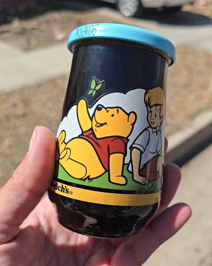 Hand holding a vintage Winnie the Pooh jar, one of the bizarre things found in old houses that left everyone confused.