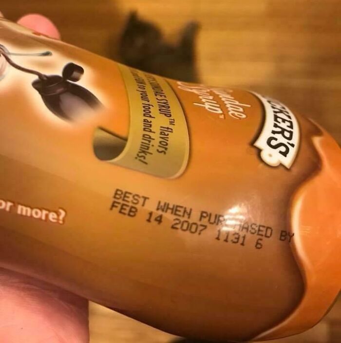 Close-up of an old syrup bottle with a best purchase date from 2007, one of the bizarre things found in old houses.