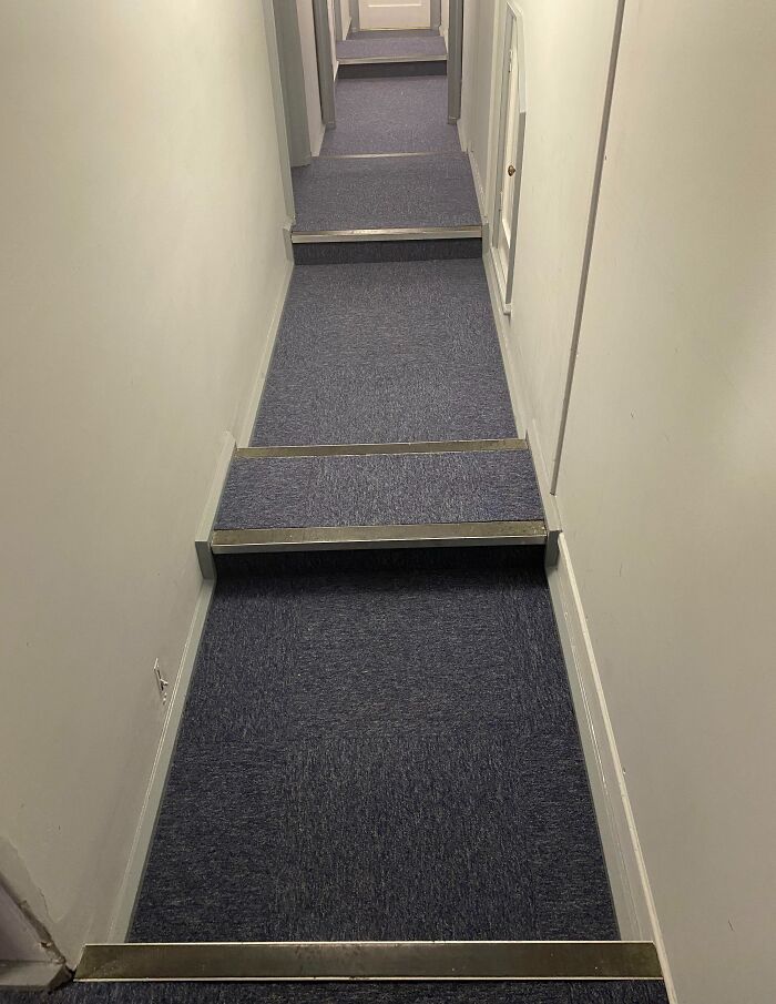 Narrow hallway with small, uneven steps that create a dangerous design and potential death trap hazard.