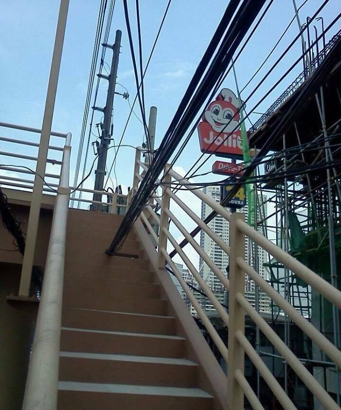 Staircase obstructed by low-hanging electrical cables, illustrating dangerous designs that could be classified as death traps.
