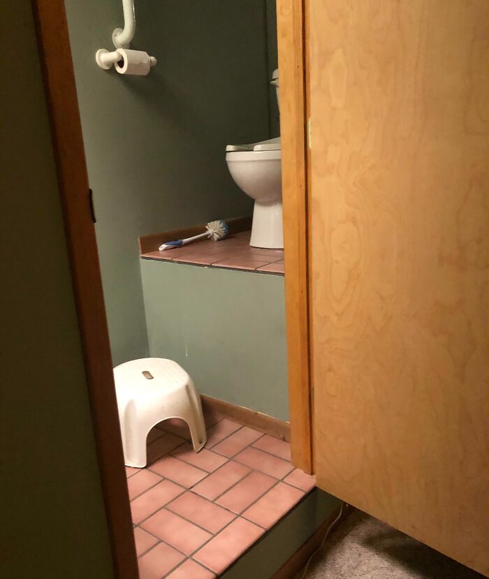 Bathroom with a raised toilet platform and step stool, illustrating one of the dangerous designs classified as potential death traps.