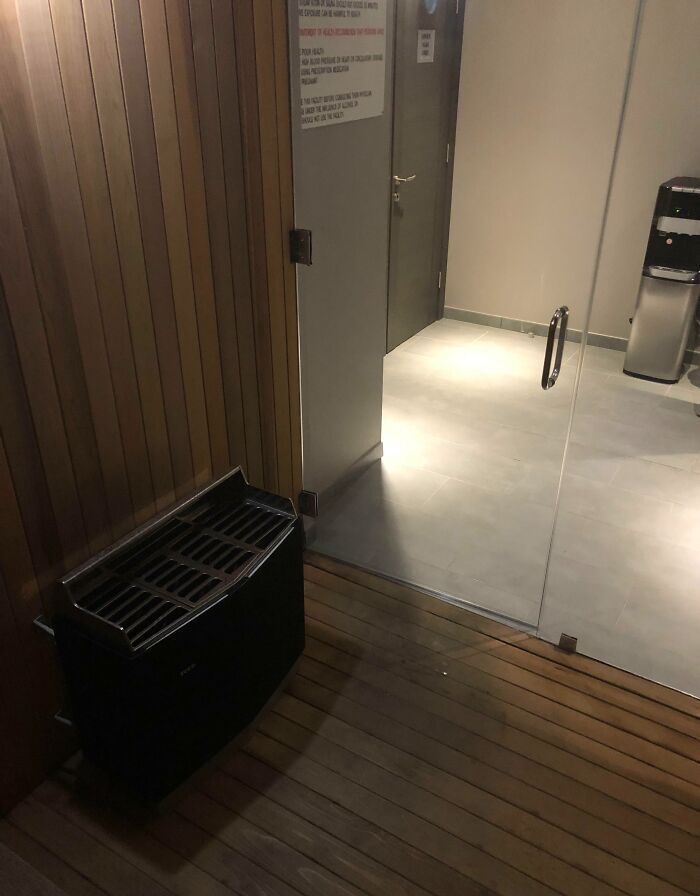 Small heater placed next to a glass door in a wooden room, illustrating a dangerous design death trap risk.