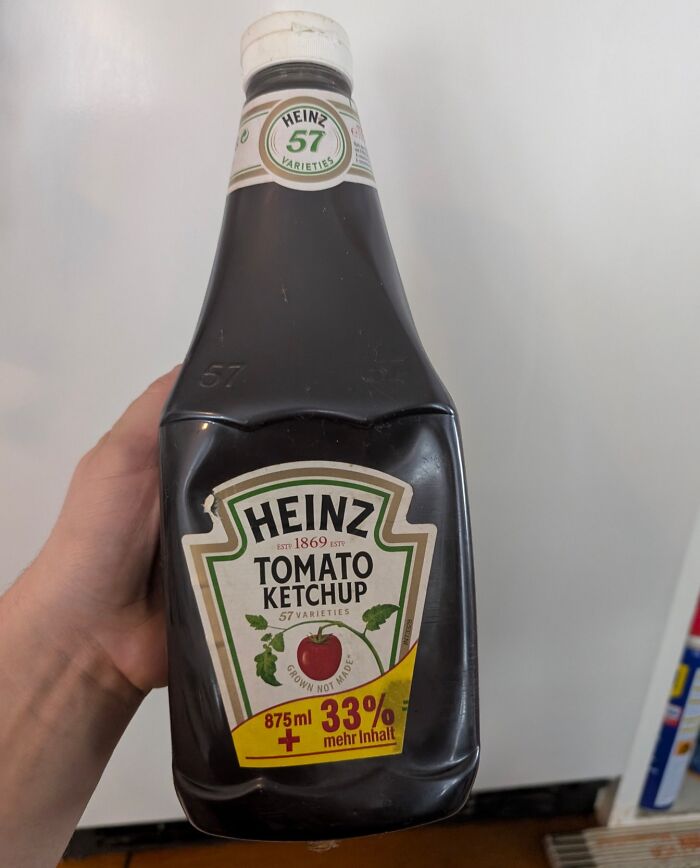 Hand holding an old Heinz tomato ketchup bottle, a bizarre thing found in an old house collection.