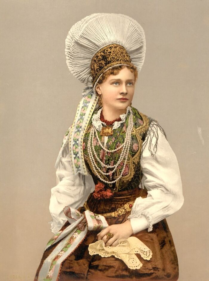 Young woman in traditional Eastern European dress featuring intricate embroidery and jewelry in vibrant cultural past photo.