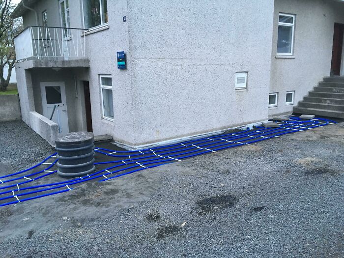 Blue pipes laid out along the exterior of a building showing a fascinating picture for curious minds learning about the world.