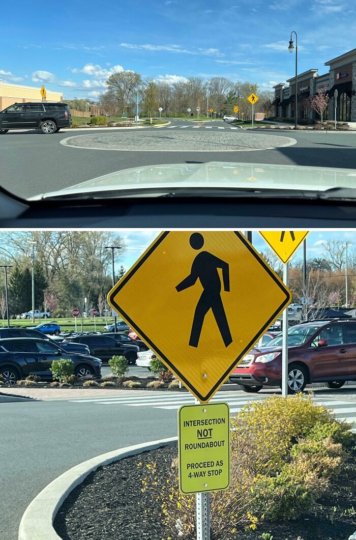 View from inside a car approaching a confusing intersection with conflicting traffic signs, a dangerous design death trap example.