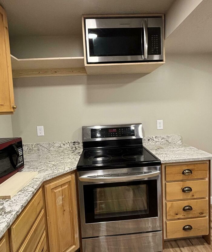 Kitchen with dangerous design features including a microwave placed above the stove creating a potential death trap hazard.