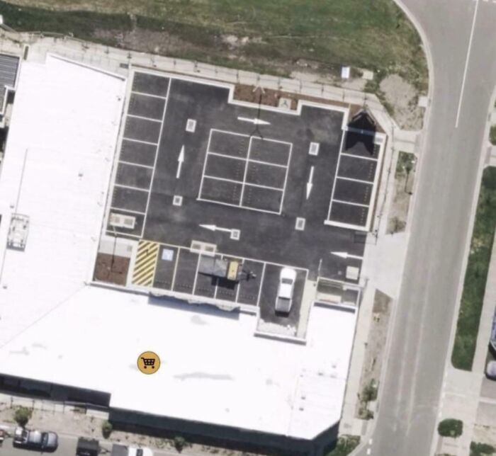 Aerial view of a parking lot with confusing arrows and markings, showcasing a dangerous design death trap example.