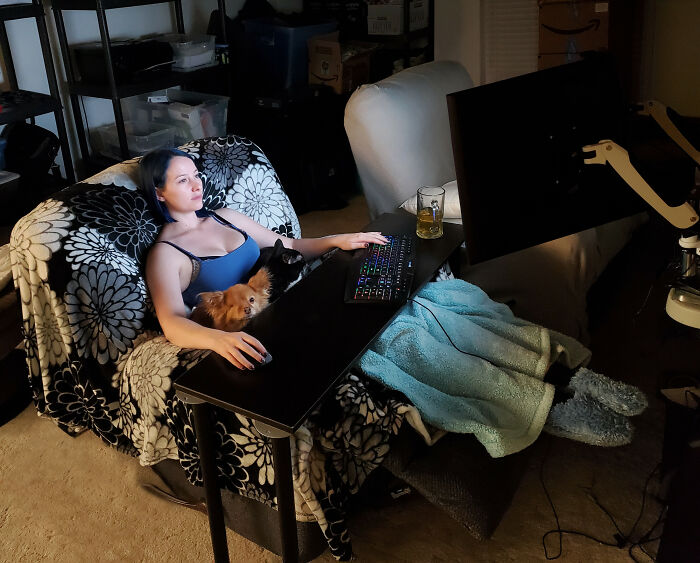 Woman working from home on computer with pets nearby, illustrating funny work-from-home memes and remote work comfort.