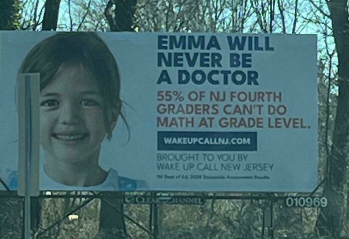 Billboard showing a young girl with text highlighting poor math skills in NJ fourth graders, a main character fail moment.