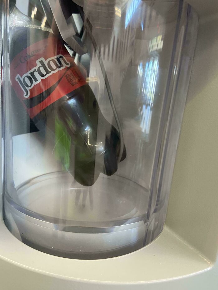 A green bottle with a red label stuck inside a transparent blender, illustrating the worst and most hilarious main character moment.