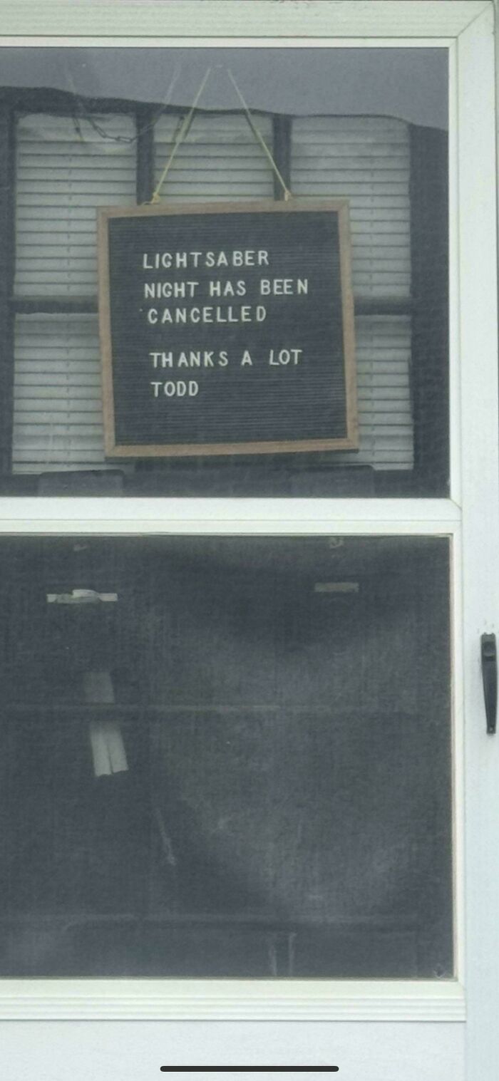 Sign hanging on a door humorously announcing lightsaber night cancellation, capturing main character moments hilariously.