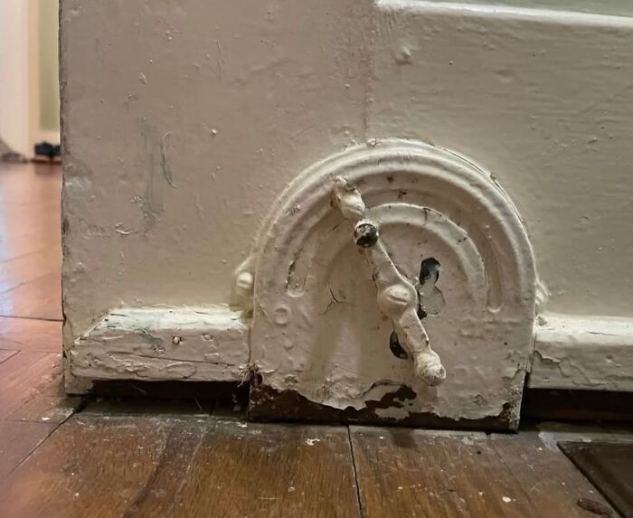 Old rusty vent cover with peeling paint on wooden floor in home with hidden and forgotten past.