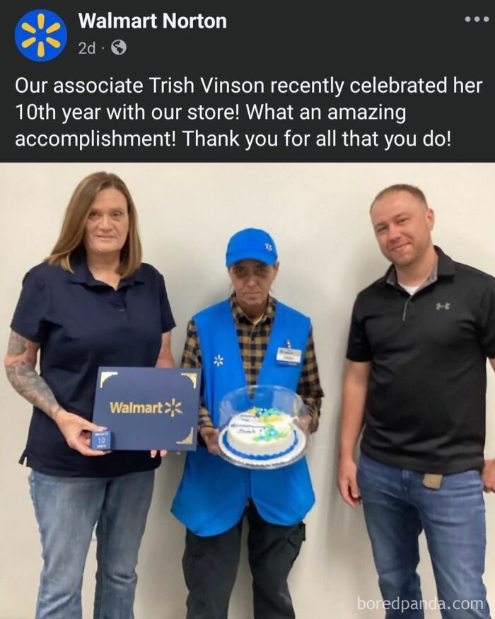 Three Walmart employees celebrating a 10th year accomplishment with a cake and a certificate in a store setting.