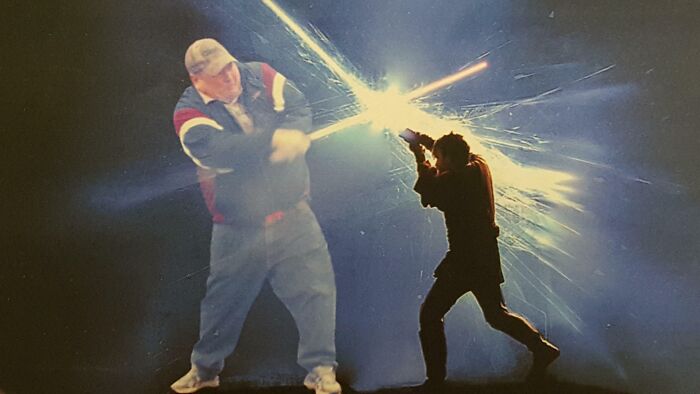 Two people engaged in a humorous Photoshop battle scene showcasing impressive photoshop skills and creativity.